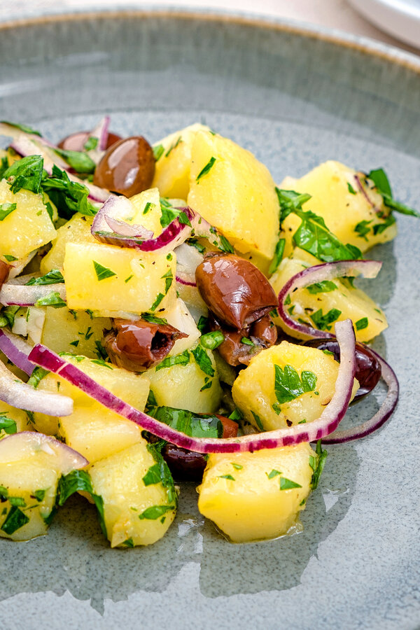 Kartoffelsalat mit schwarzen Oliven und roter Zwiebel