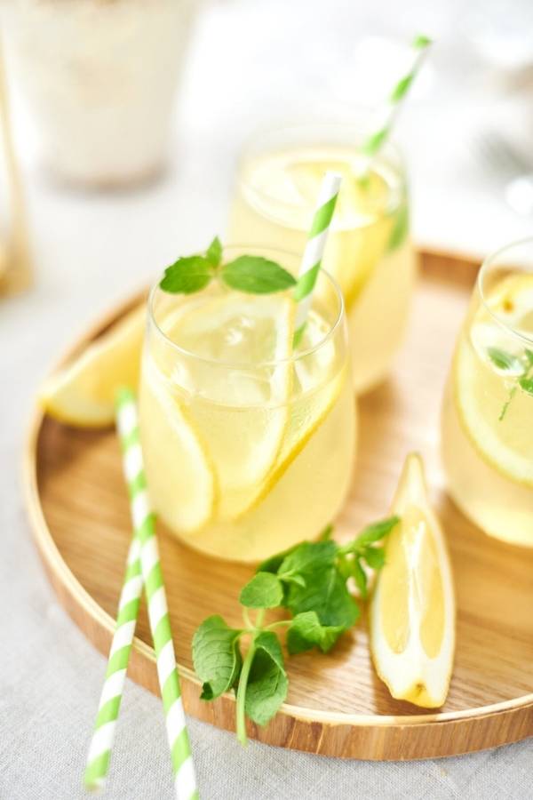 Gläser mit Limoncello Spritz Minze und Strohhalmen