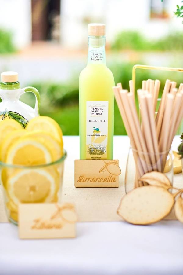 Limoncelloflasche neben Grissini und Zitronenscheiben