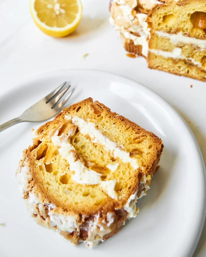 ein Stück der fertig geschichteten Colomba-Nachspeise liegt auf einem weißen Teller
