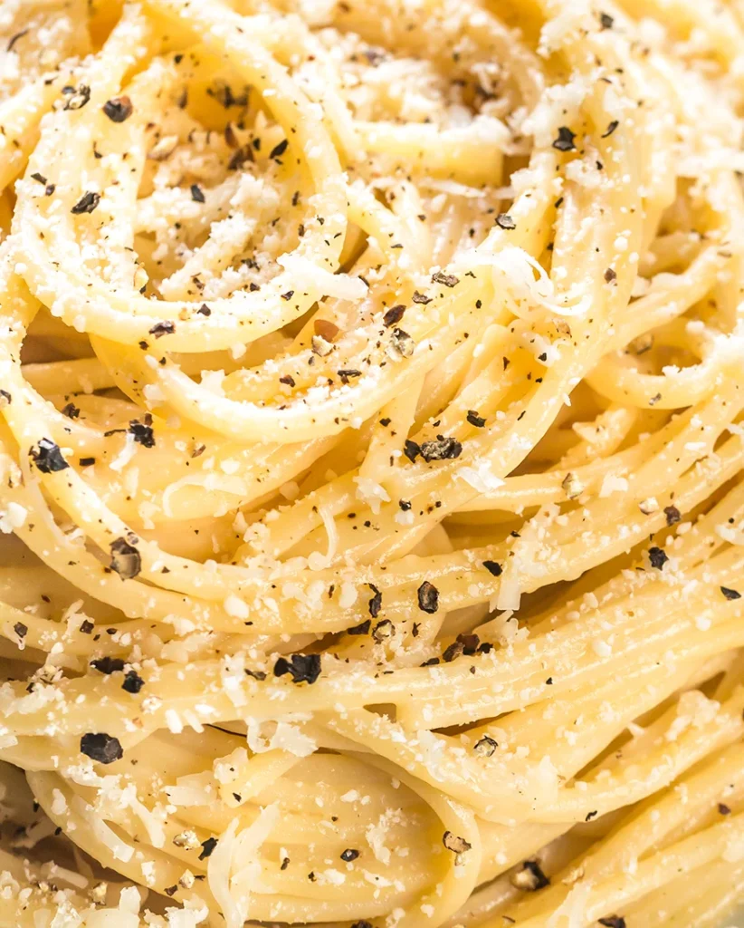 Nahaufnahme von Spaghetti Cacio e Pepe, man sieht sowohl den Abrieb des Pecorinos als auch die Pfefferstückchen