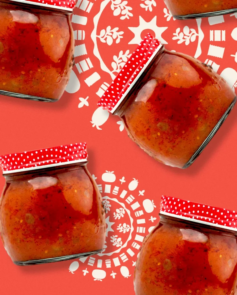 auf rotem Hintergrund fliegen freigestellte Einmachgläser mit Tomatensoße durchs Bild, im Hintergrund ist ein fein gearbeitetes Ornament zu erkennen, welches die Tomaten dekoriert