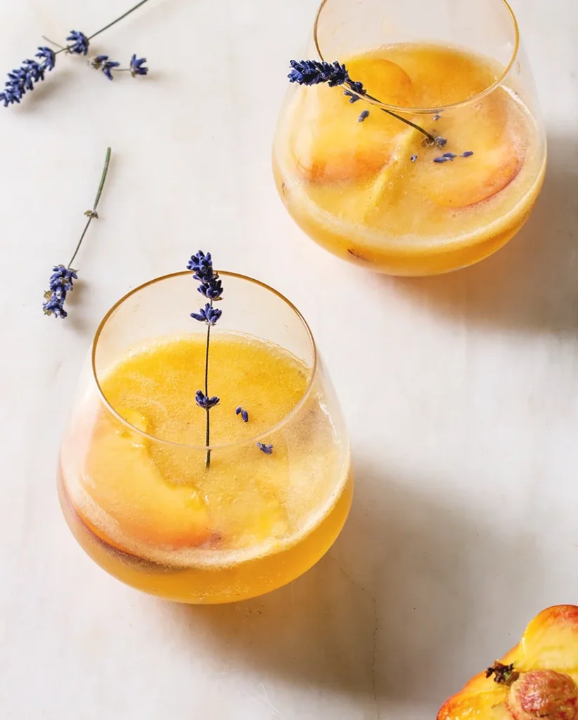 zwei Gläser Bellini Cocktail auf einem weißen Tisch