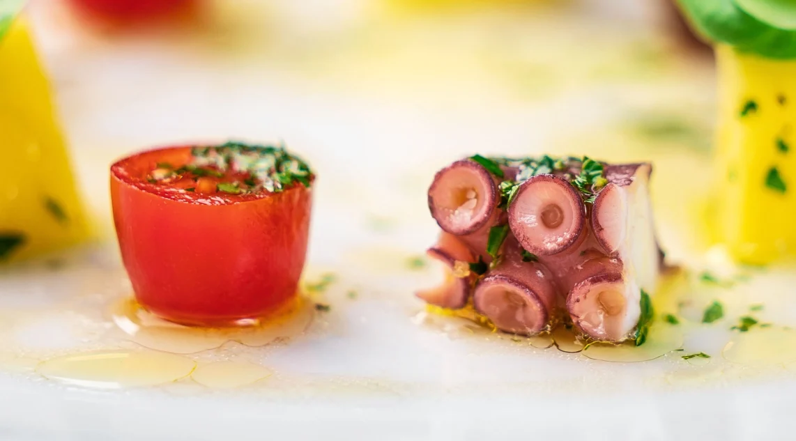 Nahaufnahme eines Polpo alla Siciliana, marinierter, gekochter Tintenfisch mit Tomaten, Olivenöl und Kräutern