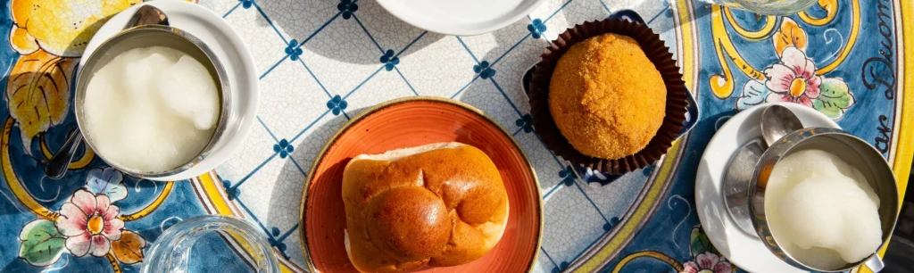 perfektes sizilianisches Frühstück: Granita al limone, Brioche col tuppo und ein Arancini