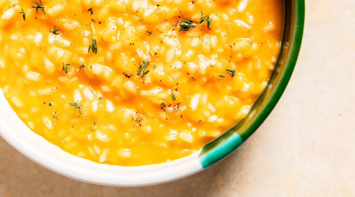 cremiges Kürbisrisotto in einer Schale mit Kräutern garniert aus der Vogelperspektive