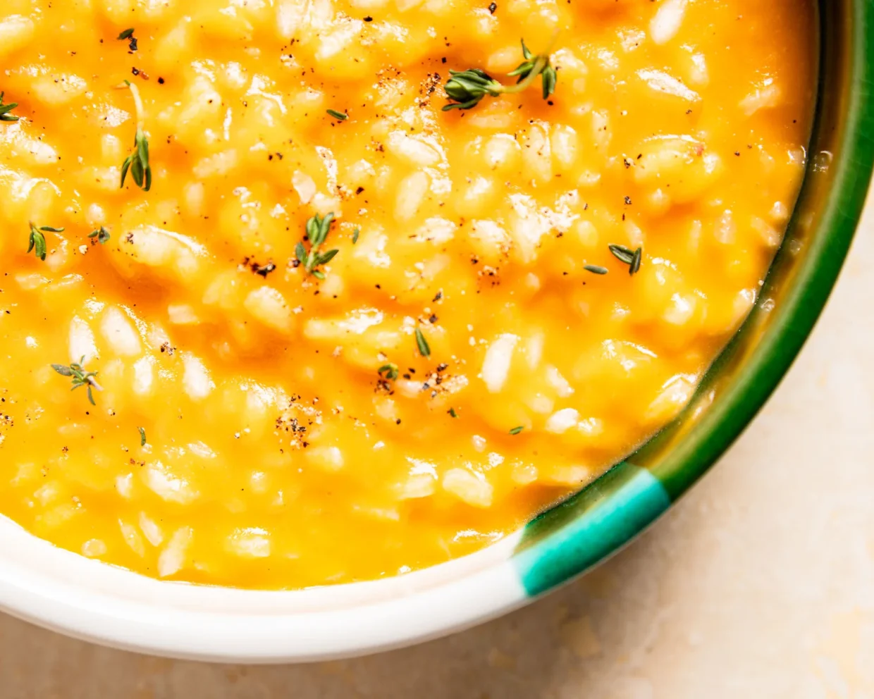 cremiges Kürbisrisotto in einer Schale mit Kräutern garniert aus der Vogelperspektive