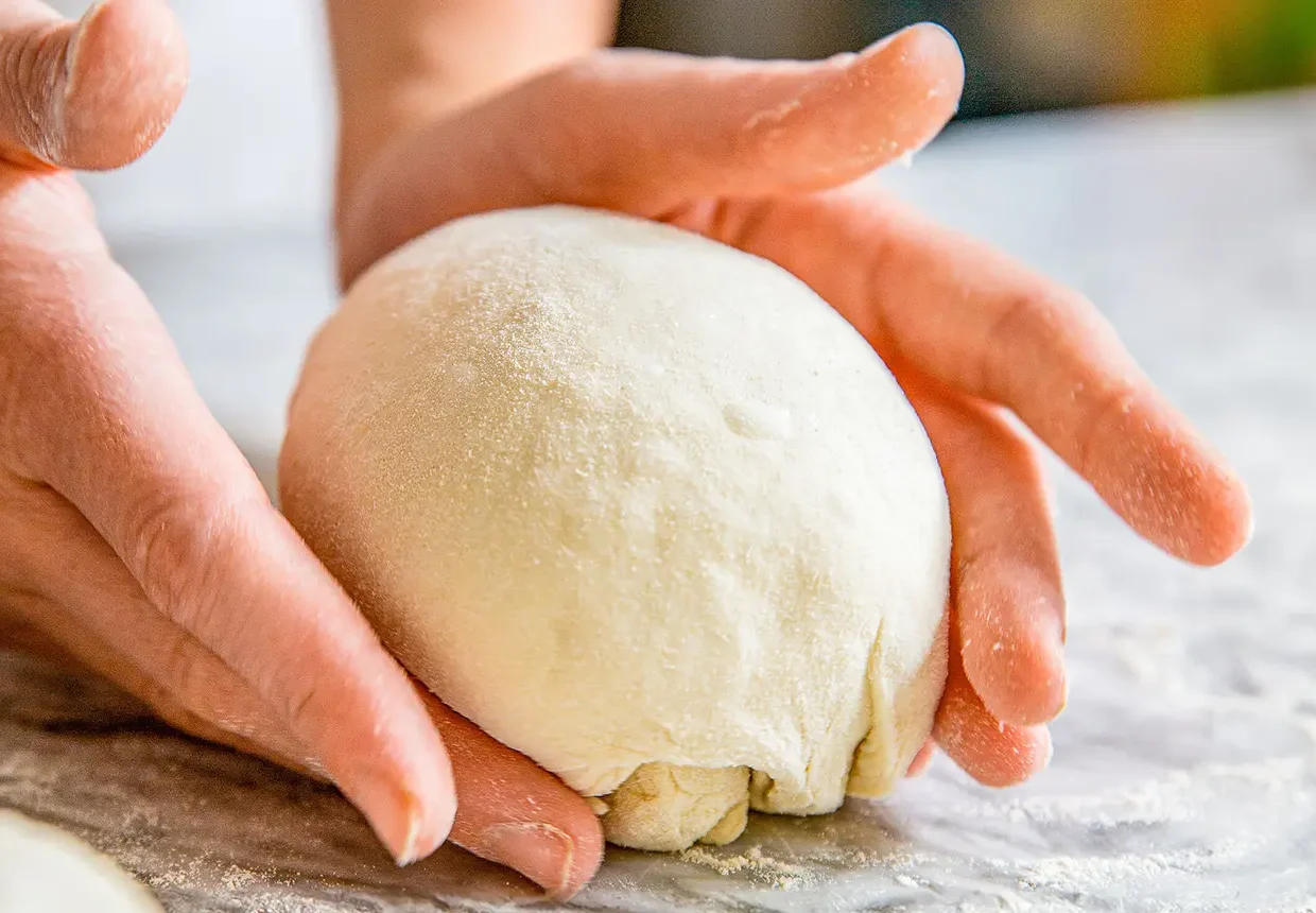 Pizzateig wird in Form gebracht