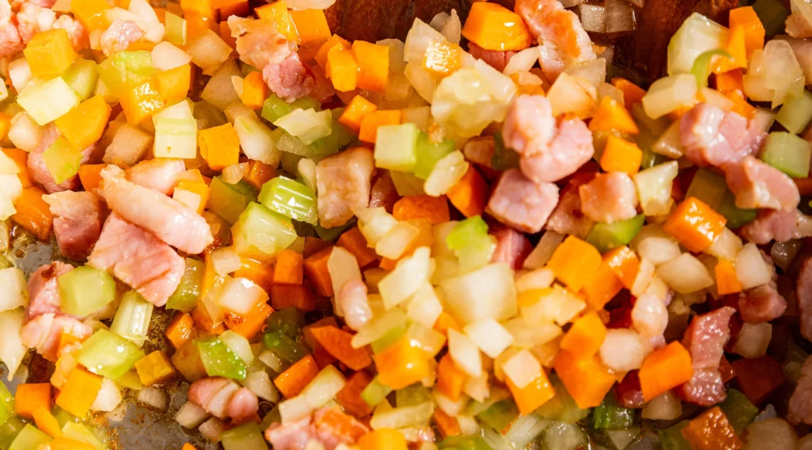 Nahaufnahme Rezept Sofritto im Topf aus Zwiebel-, Sellerie- und Möhrenwürfeln