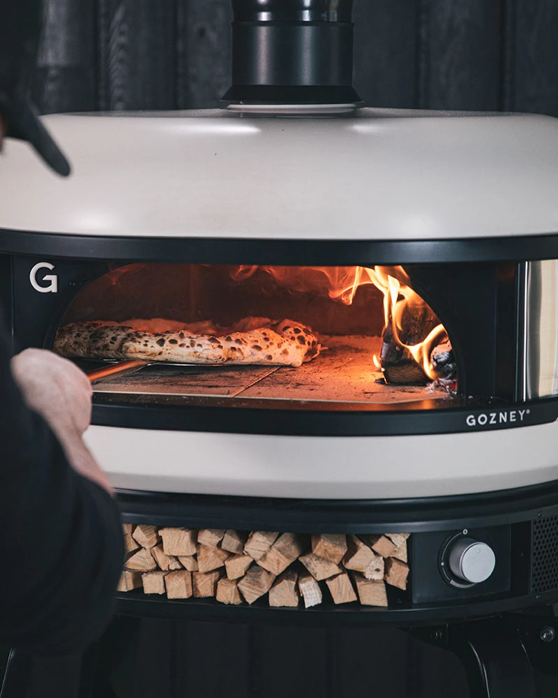 Gozney Dome Dual-Fuel – Premium Pizzaofen (Gas & Holz) – mit passenden Accessoires arrangiert