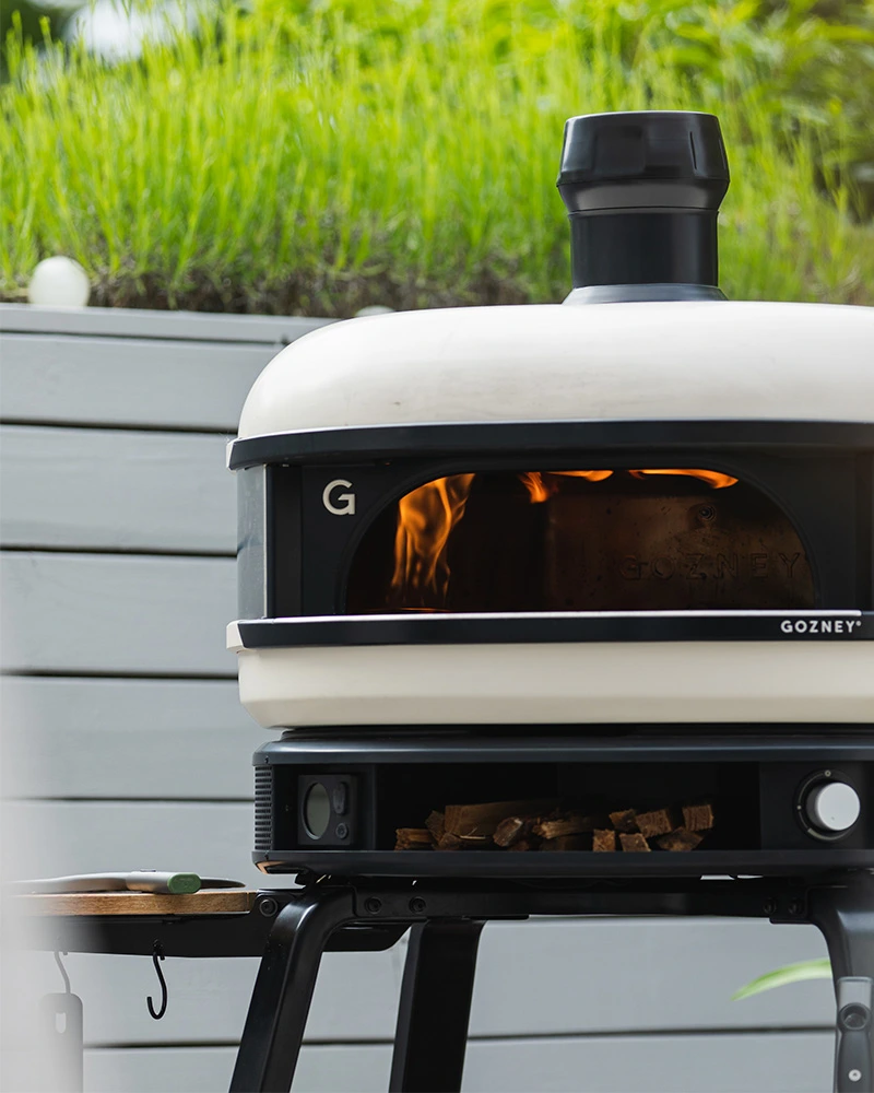 Gozney Dome Dual-Fuel – Premium Pizzaofen (Gas & Holz) – mit passenden Accessoires arrangiert