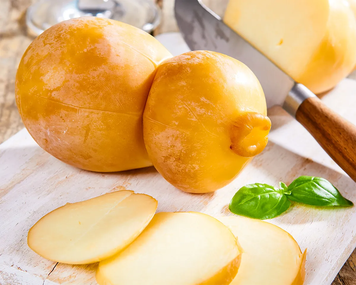 zwei Laibe Scamorza liegen auf einem Servierbrettchen
